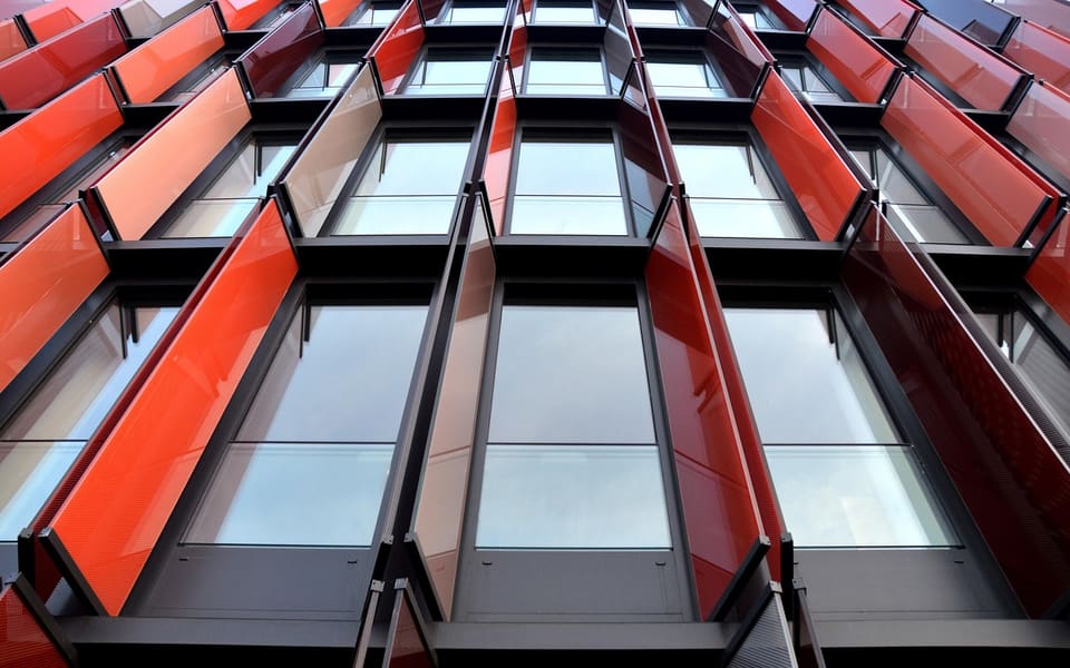 Moderne Glasfassade aus der Untersicht mit klaren Glasflächen