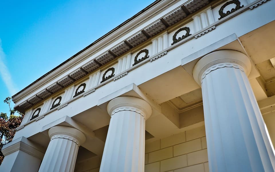 Klassische Fassade mit Säulen und feingliedrigem Gesims